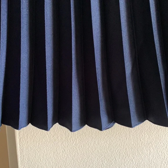 Pleated skirt is in navy blue color. - Picture 3 of 5